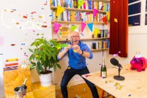 Gerhard te Velde met slingers en ballonnen om zich heen als winnaar van de Dutch Podcast Award in categorie zakelijk
